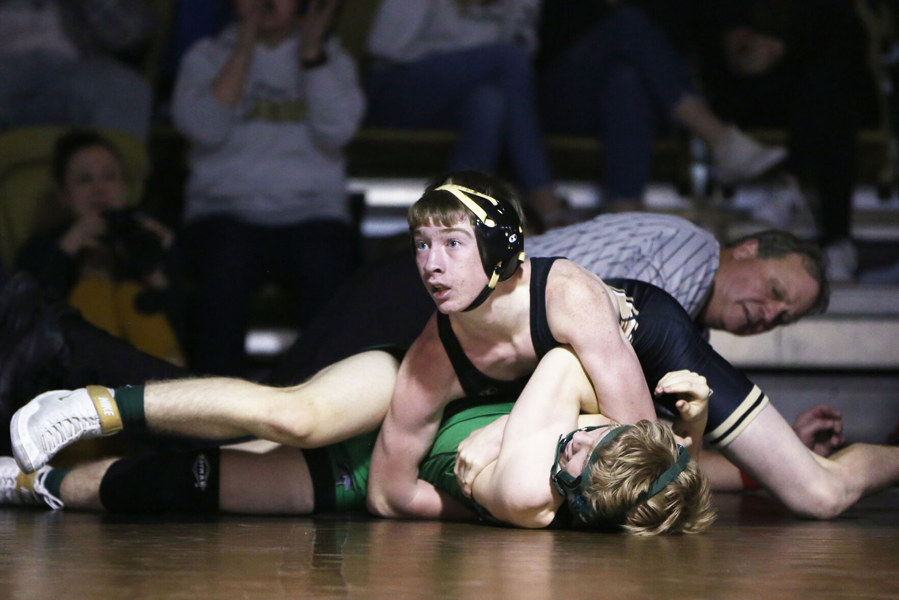 Joe Connors looks up at his the coaches while he holds down Kelly Walsh freshman Griffin Sanborn